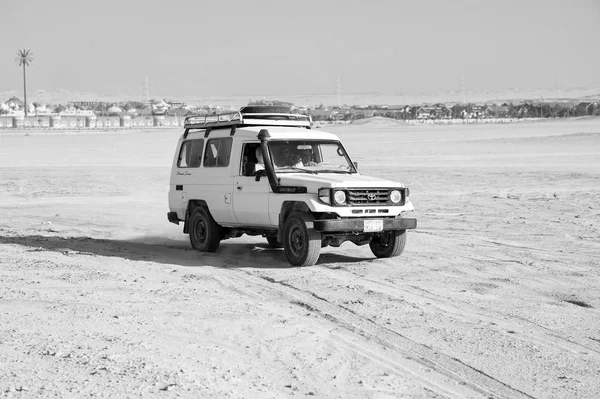 Voiture hors route conduire sur le paysage désertique. Jeep pour safari sur ciel bleu ensoleillé. Camion voiture Voyage dans les dunes de sable. Désir et aventure. Défi, vitesse et concept extrême — Photo