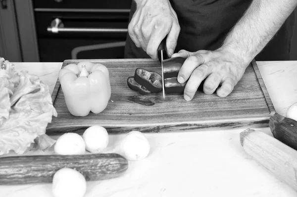 На дерев "яній дошці розрізають овочі. Ручний порізи перцю з керамічним ножем. Рецепти приготування їжі та приготування їжі. Вегетаріанське меню і здорова дієта. Концепція органічних продуктів — стокове фото