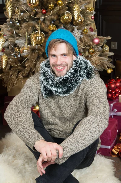 Χαμόγελο ο άνθρωπος με το καπέλο, πουλόβερ, στολίδια στο χριστουγεννιάτικο δέντρο — Φωτογραφία Αρχείου