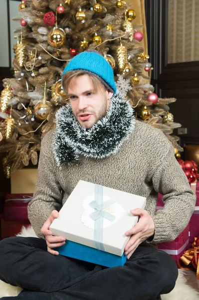 Macho en sombrero, suéter sujetar regalo envuelto — Foto de Stock