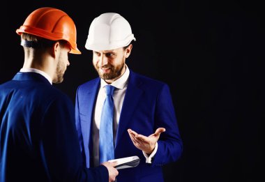 Danışman ve teknisyen kask içinde. Gülümseyen yüz görüşmeler ile mimar için dahili bina müfettişi. İnşaat ve mutlu site bina ile operatif planlayın. Muayene, destek, mimari konsepti