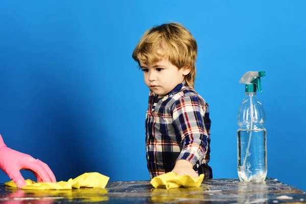 Child with concentrated face looking at hand in pink glove. — Stock Photo, Image