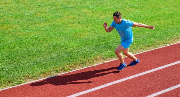 Treinamento de velocistas na pista do estádio. Corredor capturado no ar. Desafio de corrida de curta distância. Aumenta a velocidade. Atleta executar pista de fundo grama. Corre em forma. Desafio de corrida para iniciantes — Fotografia de Stock