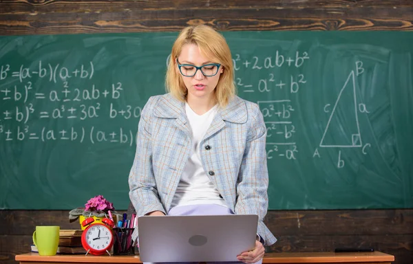 Enseñanza en ambiente no formal. Maestro de la generación moderna. Mujer profesora mantenga portátil sentarse mesa aula pizarra fondo. Increíble profesora dama sabe cómo mantenerse en contacto generación moderna — Foto de Stock