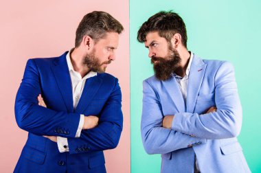 İşadamları şık görünüm ceket pembe mavi renkli. Gergin yüz ifadesi rakip. İş rekabet ve çatışma. Rakip takım gergin sakallı yüzü olan iş ortakları