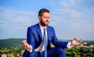 Ruhu içinde sakin tutmak. İşadamı resmi takım elbise lotus poz ve meditasyon oturup açık havada. Girişimci dakika dinlenip, meditasyon bulmak. Adam zihnini açık tutmaya çalış. Gevşeme tekniği