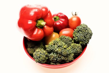 Brokoli, kırmızı ve sarı domates ve tabakta dolma biber.