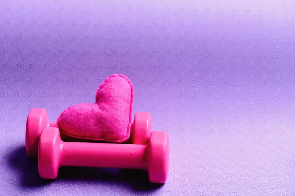 Sombrillas de plástico rosa cerca de corazón de juguete suave — Foto de Stock