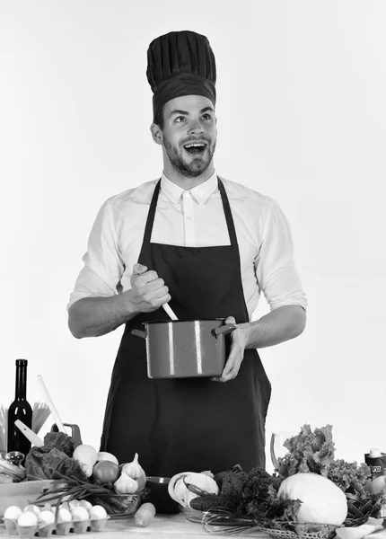 Mannen i kock hatt och förkläde mixar i kruka — Stockfoto