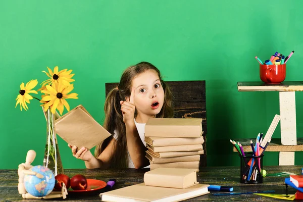 Estudante senta-se na mesa com artigos de papelaria coloridos, livros, globo — Fotografia de Stock