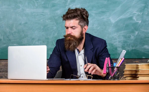 Online school and education. Distant schooling concept. Teacher bearded mature man teach online using laptop and internet. Teacher works as distant educator. Man looks at laptop screen busy working — Stock Photo, Image