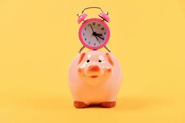 Time save Concept. Pink piggy bank with stopwatch on top