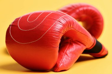 Sarı arka planda kırmızı boks eldivenleri düz yatıyordu. Spor ve boks kavramı.