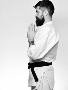 Beyaz arka planda beyaz kimonolu sakallı adam.