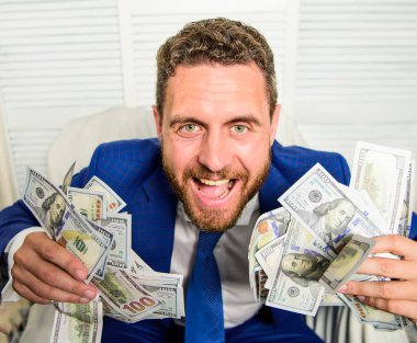 Businessman formal suit hold cash dollars hands. Che k out my profit this month. Earn money easy business tips. Man cheerful happy businessman with pile dollar banknotes. Profit and richness concept