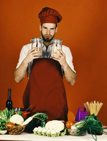 Cook works in kitchen near table with vegetables and tools — Stock Photo, Image