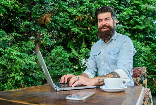 Create content for web blog. Hipster freelancer work online blog notebook. Blogger create post while enjoy coffee. Man bearded businessman sit terrace with laptop and cup of coffee. Freelance benefit