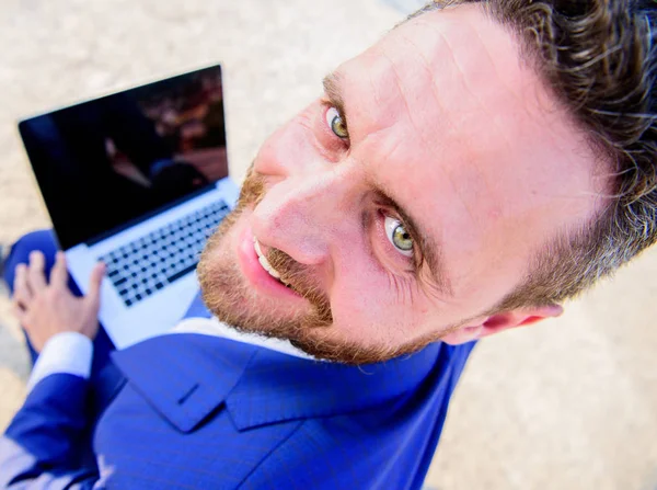 Agradable día de trabajo al aire libre. Hombre de negocios traje formal mira hacia atrás mientras sostiene la computadora portátil de pantalla abierta. Hombre sonriente cara alegre trabajo con el ordenador portátil de cerca. Soleado día de verano gran oportunidad para trabajar al aire libre — Foto de Stock