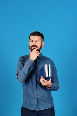 Düşünceli yüz ve sakal tutar yığın kitap olan adam