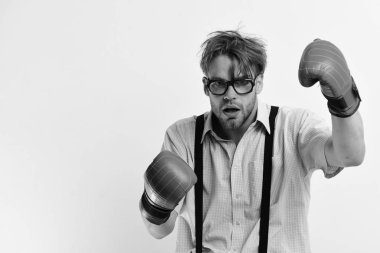 Tüylü ve donuk suratlı adam boks eldiveni giyiyor.