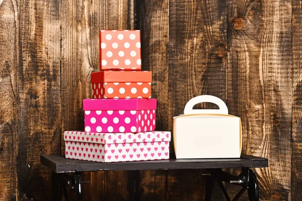 Branco senhoras bolsa e muito doce apresenta caixas na bandeja preta no fundo de madeira, espaço de cópia . — Fotografia de Stock