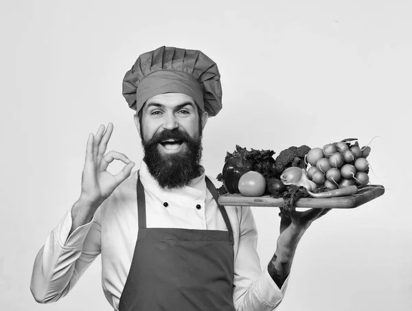 Chef-kok vertoont ok houden bord met fruit. Koken met blij gezicht Bourgondië uniforme houdt salade ingrediënten — Stockfoto