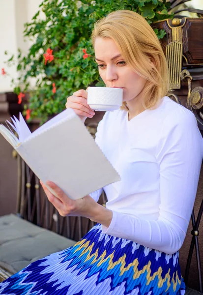 おいしいコーヒーと完璧な週末に興味深い本最適な組み合わせのマグカップ。コーヒー毎朝同じ場所の毎日の儀式を飲む女の子。完璧な朝のコンセプトです。女性アウトドア ドリンク カフェ テラスがあります。 — ストック写真