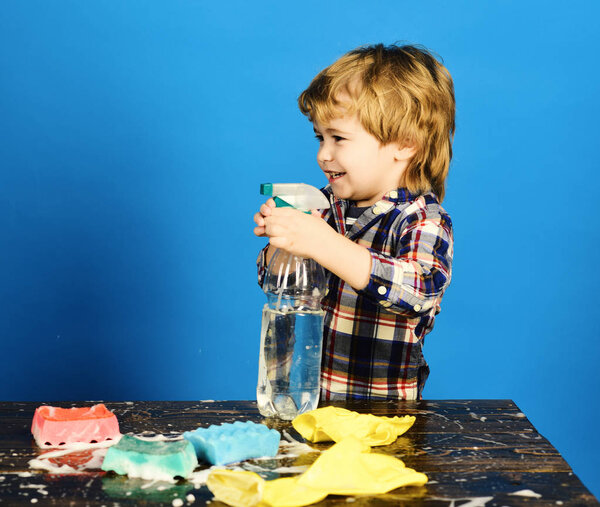 Child near table with cleaning supplies on.