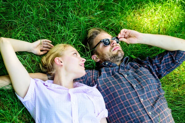 Man unshaven and girl lay on grass meadow. Guy and girl happy carefree enjoy freshness of grass. Closer to nature. Couple in love relaxing lay at meadow. Nature fills them with freshness and peace — Stock Photo, Image