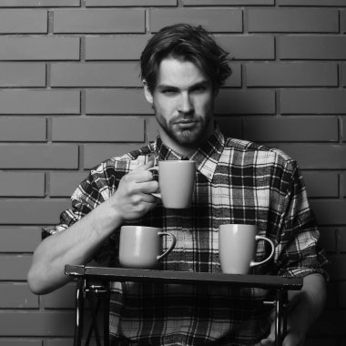 Duvarda bardakları tutan yakışıklı adam.