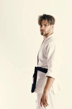 Adam siyah kuşaklı beyaz kimonoyla poz veriyor. Sağlıklı yaşam tarzı