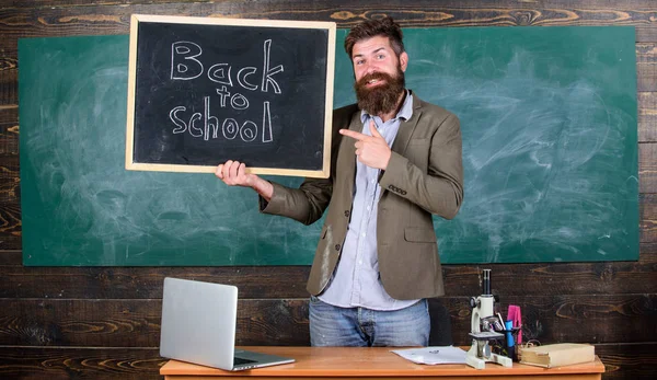 Чоловік бородатий тримає напис на дошці назад до школи. Наймає вчителів на новий навчальний рік. Перегляд відданих вчителів доповнює кваліфікованих викладачів робочої сили. Назад до шкільних вчителів вербування — стокове фото