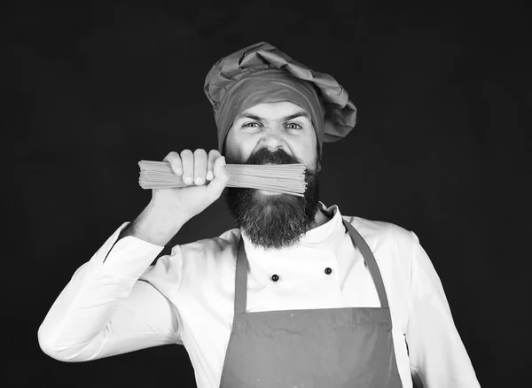 Italienska restaurangkoncept. Mannen eller hipster med skägg innehar makaroner — Stockfoto