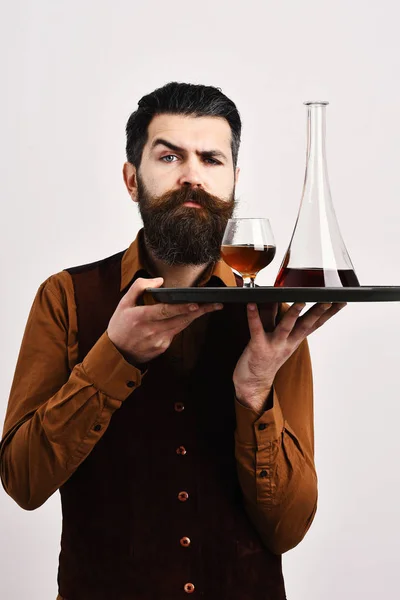 Waiter with glass and bottle of whiskey on tray. — Stock Photo, Image