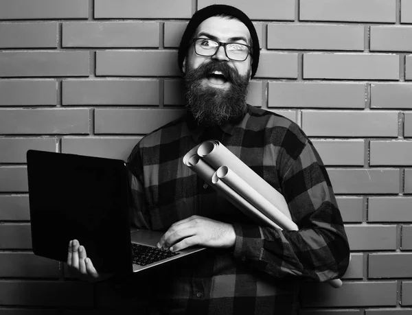 Brutalny, biały hipster trzymający laptopa i papier ręczny — Zdjęcie stockowe