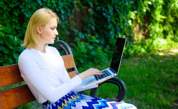 Remote jobs browse top freelance remote work opportunities. Woman with laptop works outdoor green nature background. Lady freelancer working in park. Girl sit bench with notebook looking new job