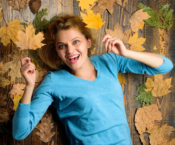 Ősz és őszi szezon fogalom. Őszi hangulatú attribútumok. Nő csinos hölgy élvezze a szezon hold őszi száraz leveleket. Lány szőke feküdt a fa háttér orange elhagyja, felülnézet — Stock Fotó