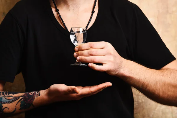 Alcoholic drinks spirits. Male hands hold alcoholic beverage