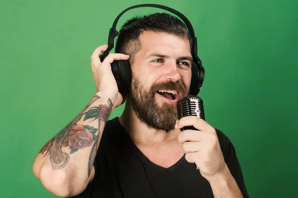 Cantante con barba y cara sonriente disfruta de la música — Foto de Stock