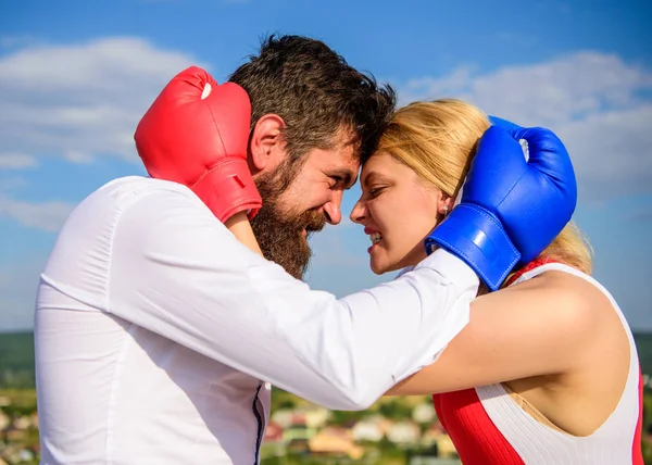 Couple in love boxing gloves hug blue sky background. Man beard and girl cuddle happy after fight. Family life happiness and relation problems. Reconciliation and compromise. Fight for your happiness