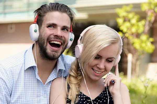 Man with woman enjoy music outdoor with urban background, defocused