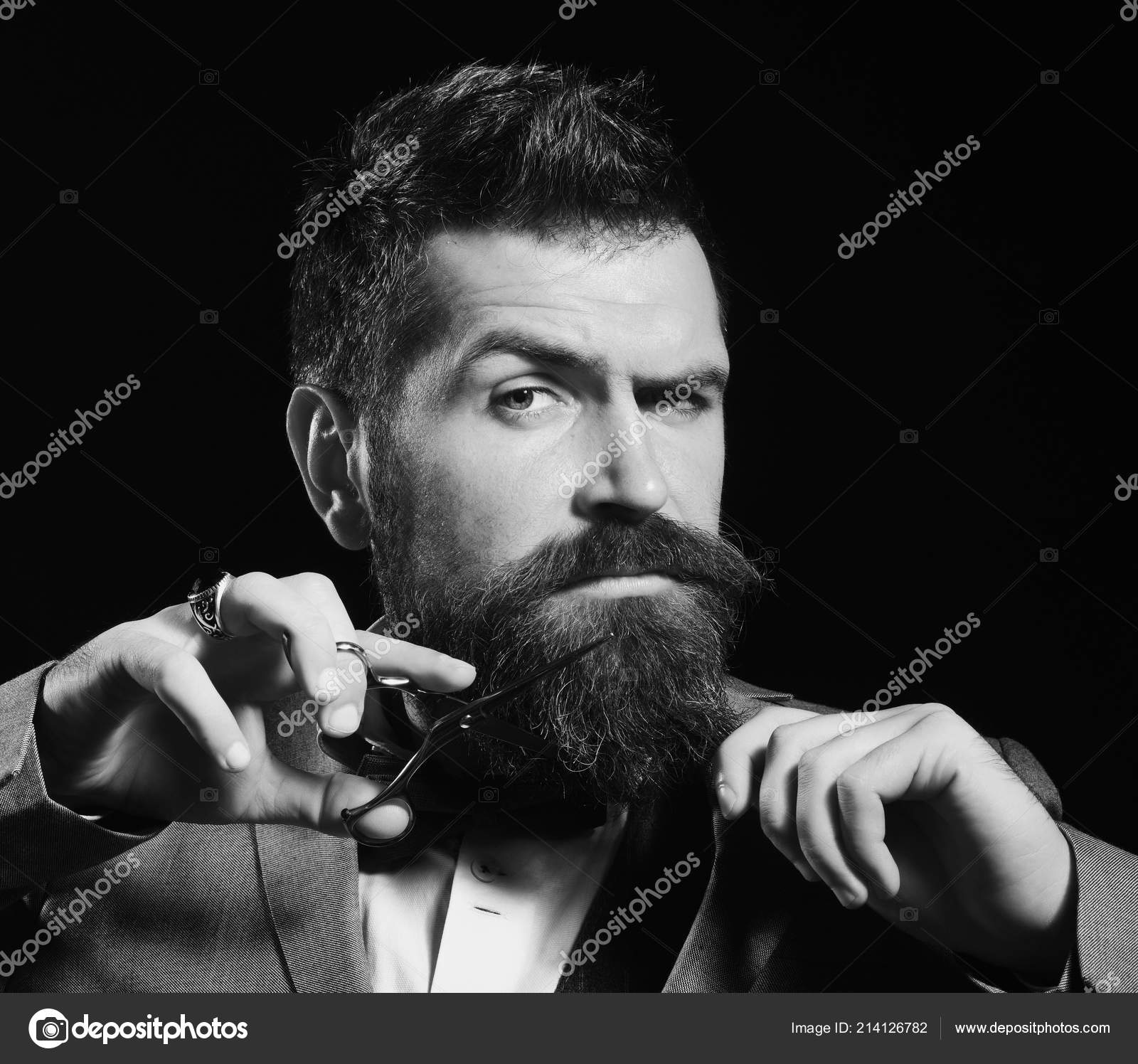 Concepto publicitario de barbería. El hombre con barba sostiene