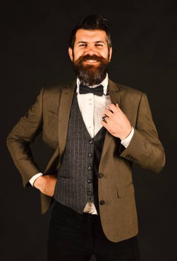 Eskimiş şık takım elbiseli ve kahverengi arka planda yelek giyen adam..