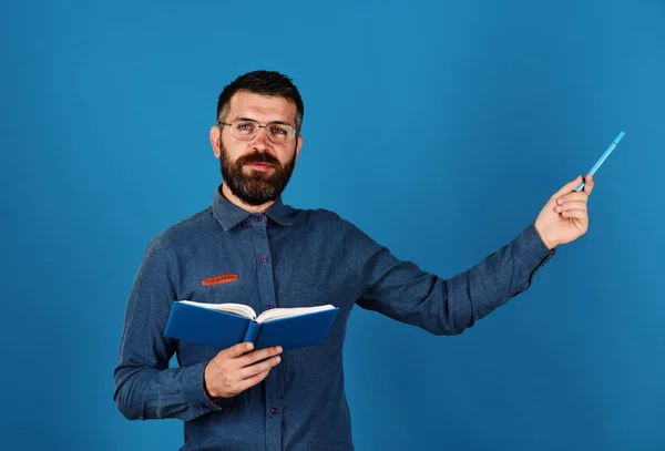 Учитель носит очки и держит в руках органайзер и ручку. Человек с бородой и книгой. Концепция знаний и уроков — стоковое фото