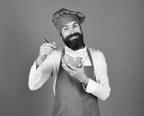 Man eller hipster med skägg håller köksutrustning på blå bakgrund. — Stockfoto