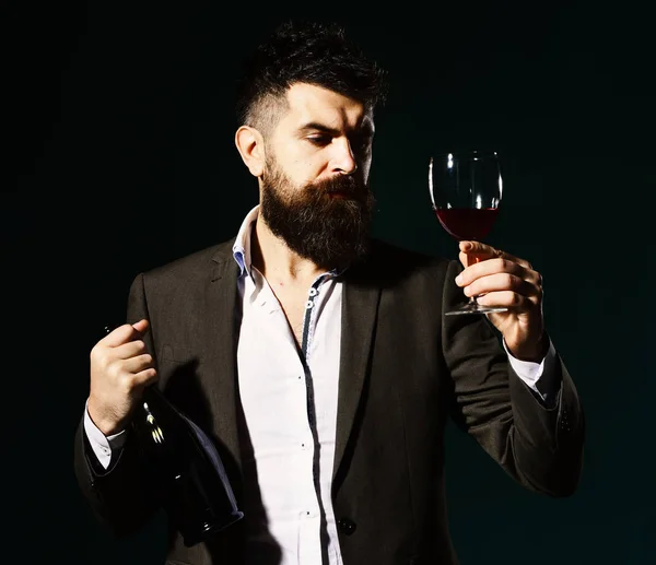 エメラルドを背景に髭と高価なアルコールを持つデグストレーター — ストック写真