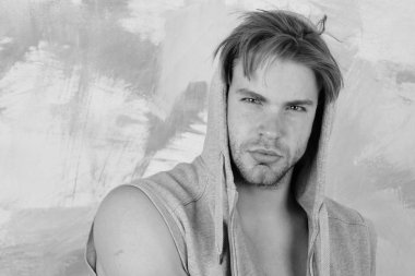 Kıl ve mavi gözleri olan adam. Adam kolsuz hoodie giyer