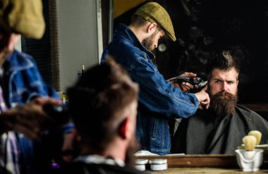 Hipster istemci Başlarken saç kesimi. Saç kesimi kavramı. Kuaför saç kesme makinesi ile saç modeli sakallı, berber arka plan için çalışır. Kuaför styling saç kesme makinesi ile acımasız sakallı istemci