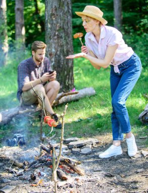 Hasır şapka çalışırken kız gıda doğa arka plan kavrulmuş. Lezzetli piknik yemeği. Sopa üzerinde pişirmek için gıdalar. İpuçları her kamp kamp ateşi pişirme hakkında bilmeniz gerekenler. Kamp ateşi yemek pratik öneriler geliştirmek