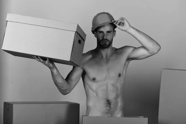 Sexuality and building concept: τύπος με σέξι κορμό κρατώντας χαρτοκιβώτιο — Φωτογραφία Αρχείου